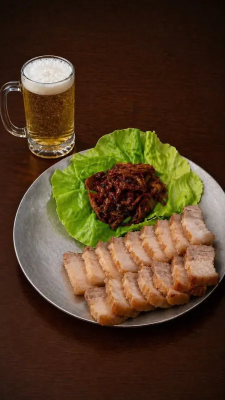 Sliced pork belly with kimchi, lettuce, and a beer mug